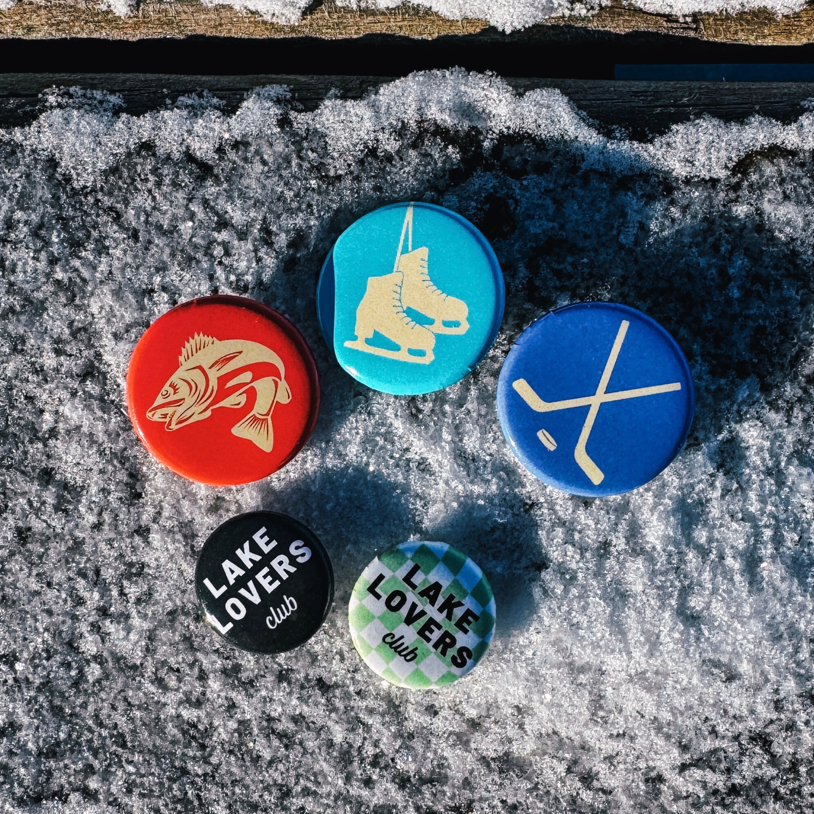 Set of buttons with hardwater-themed designs on a snowy background