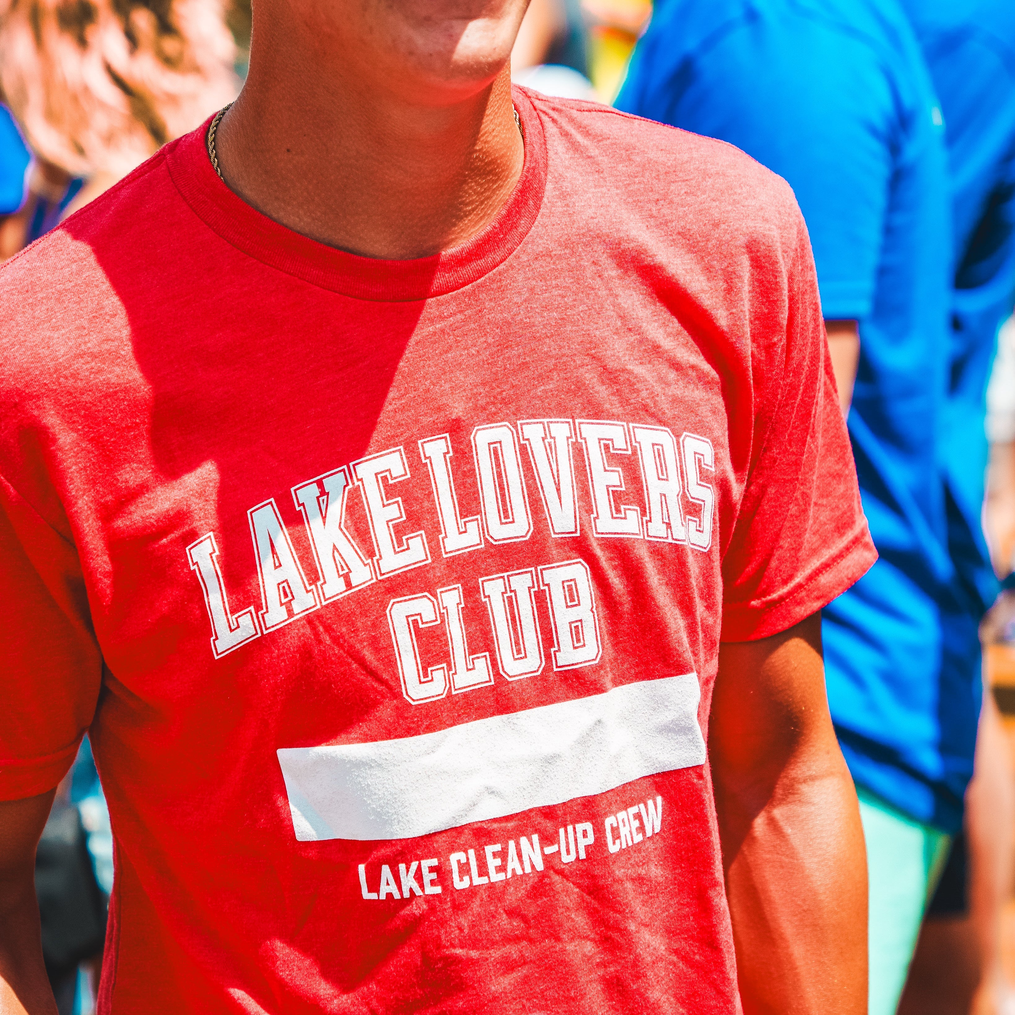 Person wearing a red 'Lake Lovers Club' t-shirt with a blurred background