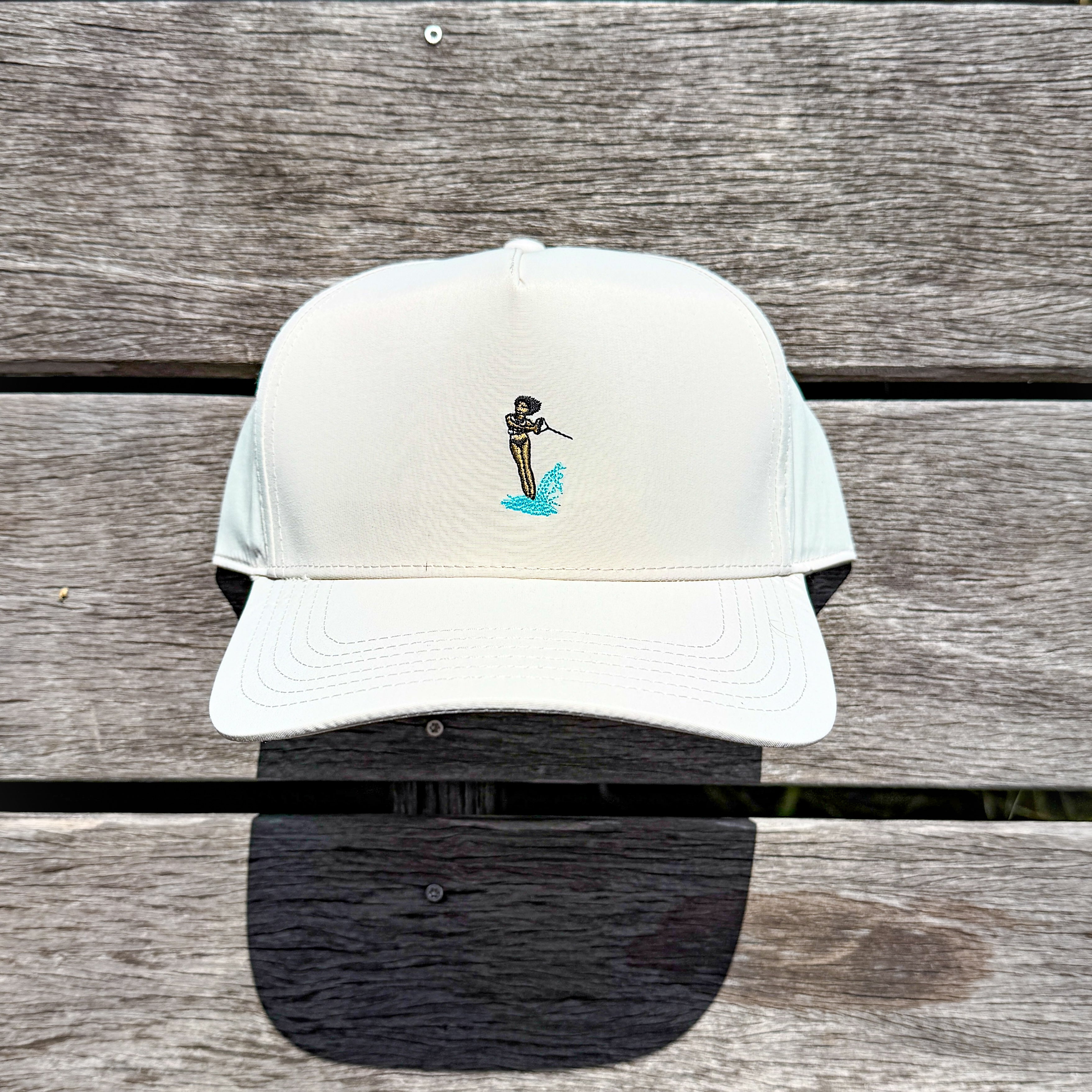 White cap with embroidered design on a wooden surface