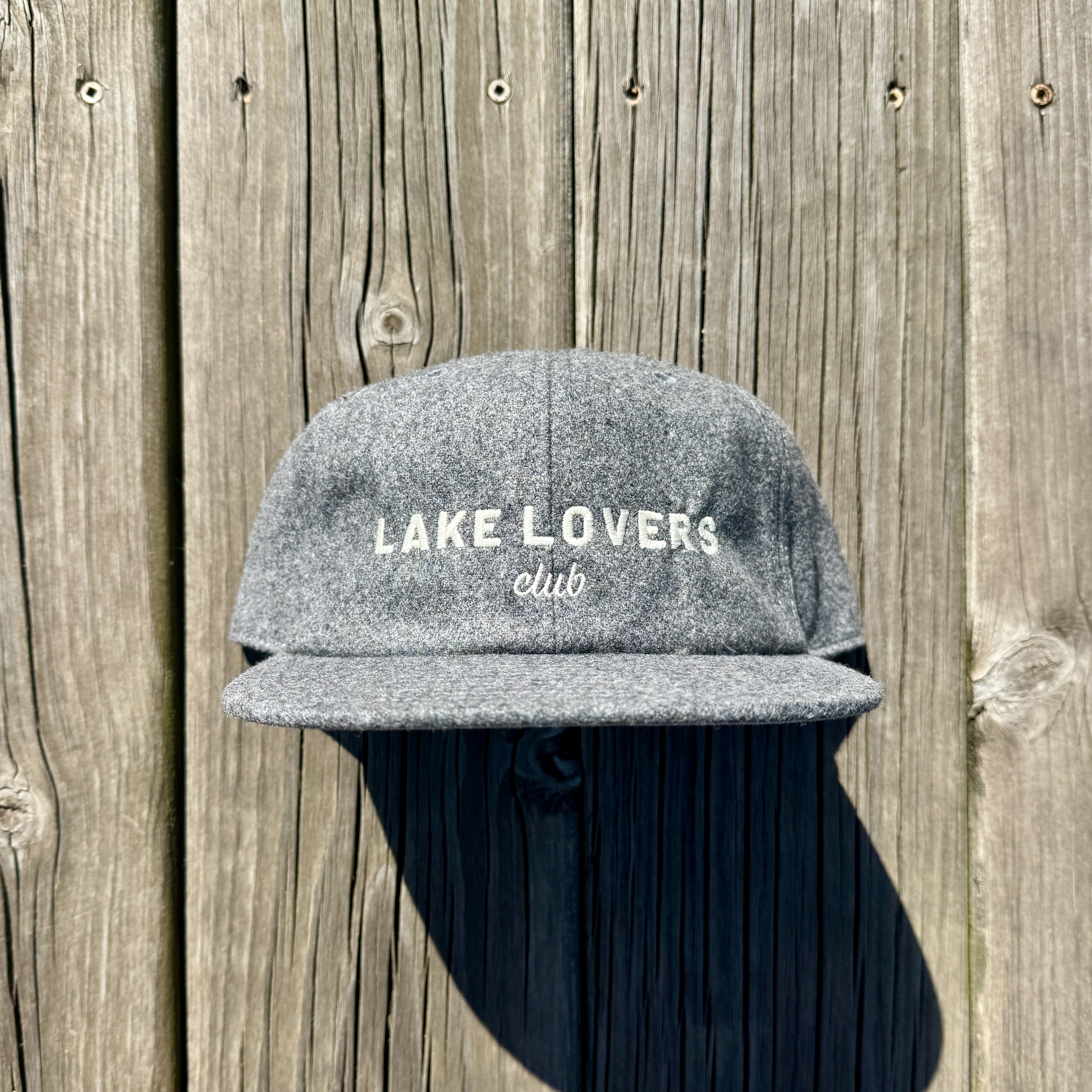 Gray cap with 'Lake Lovers Club' text on a wooden background