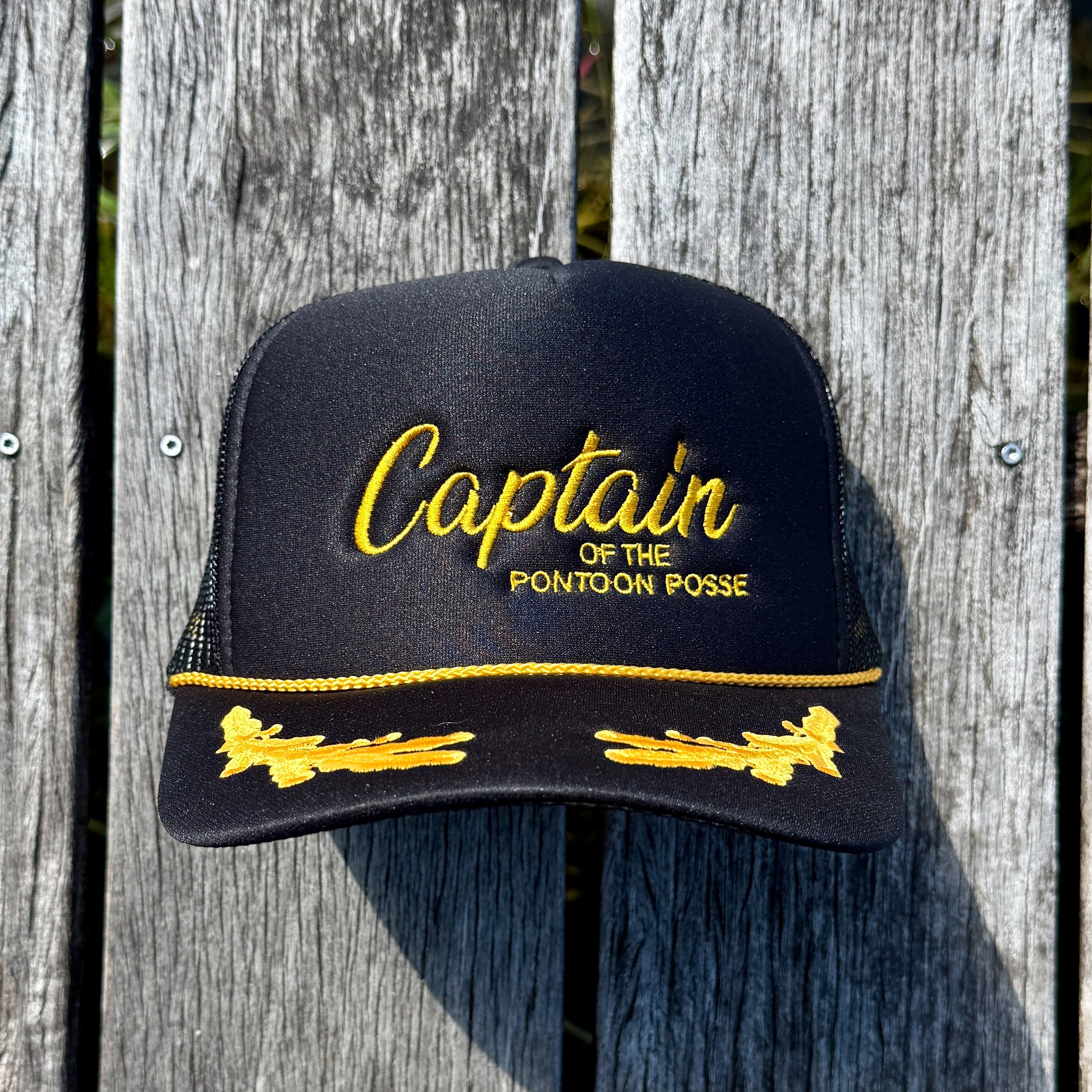 Black cap with yellow text and designs on a wooden background