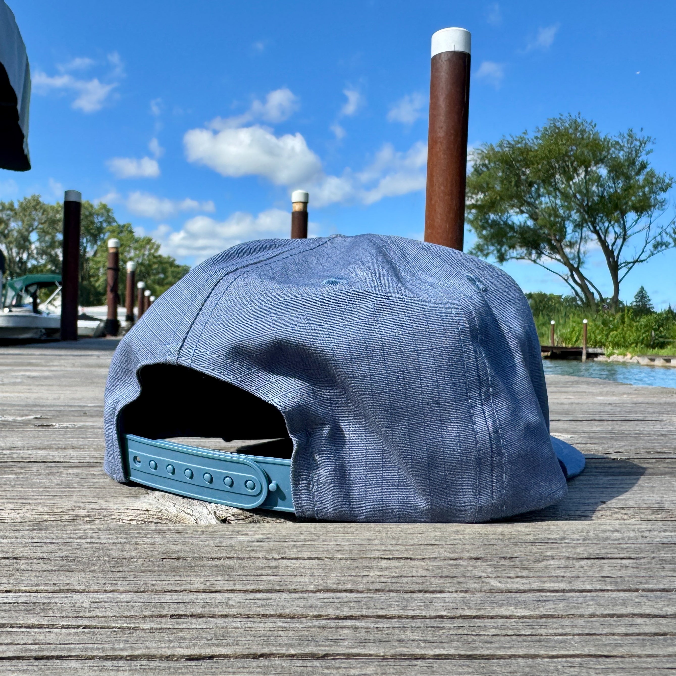 Blue cap on a wooden dock with a scenic background