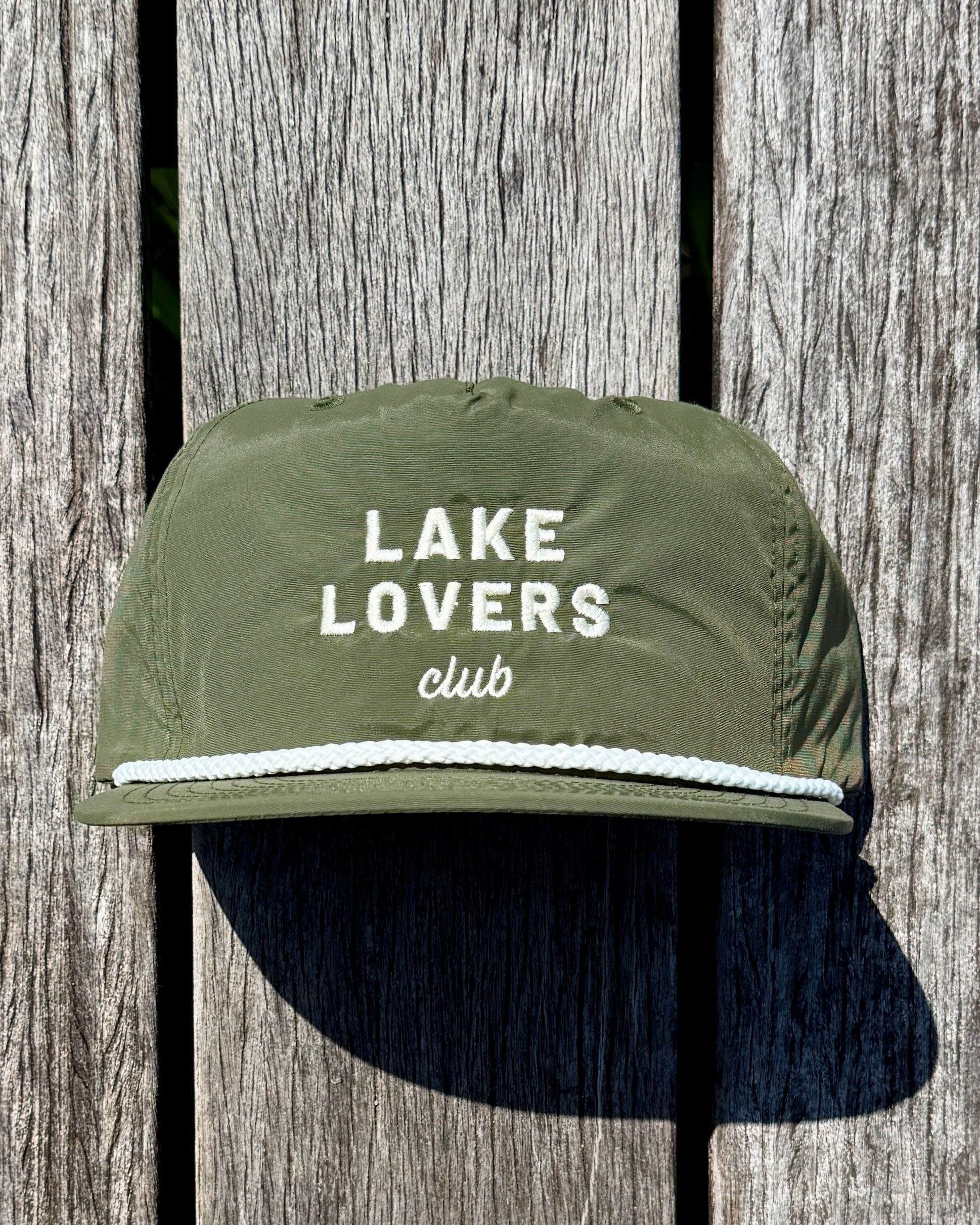 Green cap with 'Lake Lovers Club' text on a wooden background