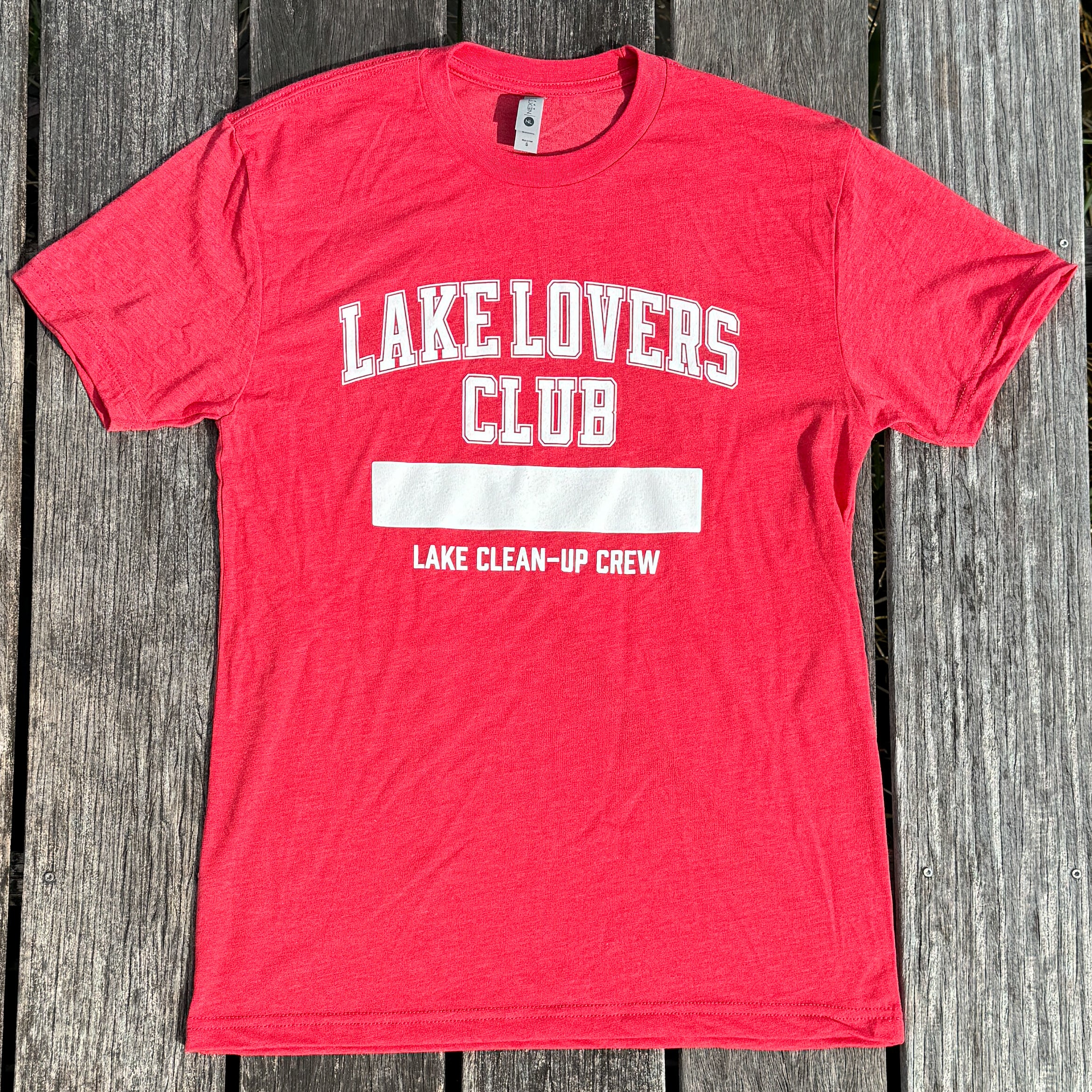 Red t-shirt with 'Lake Lovers Club' text on a wooden surface