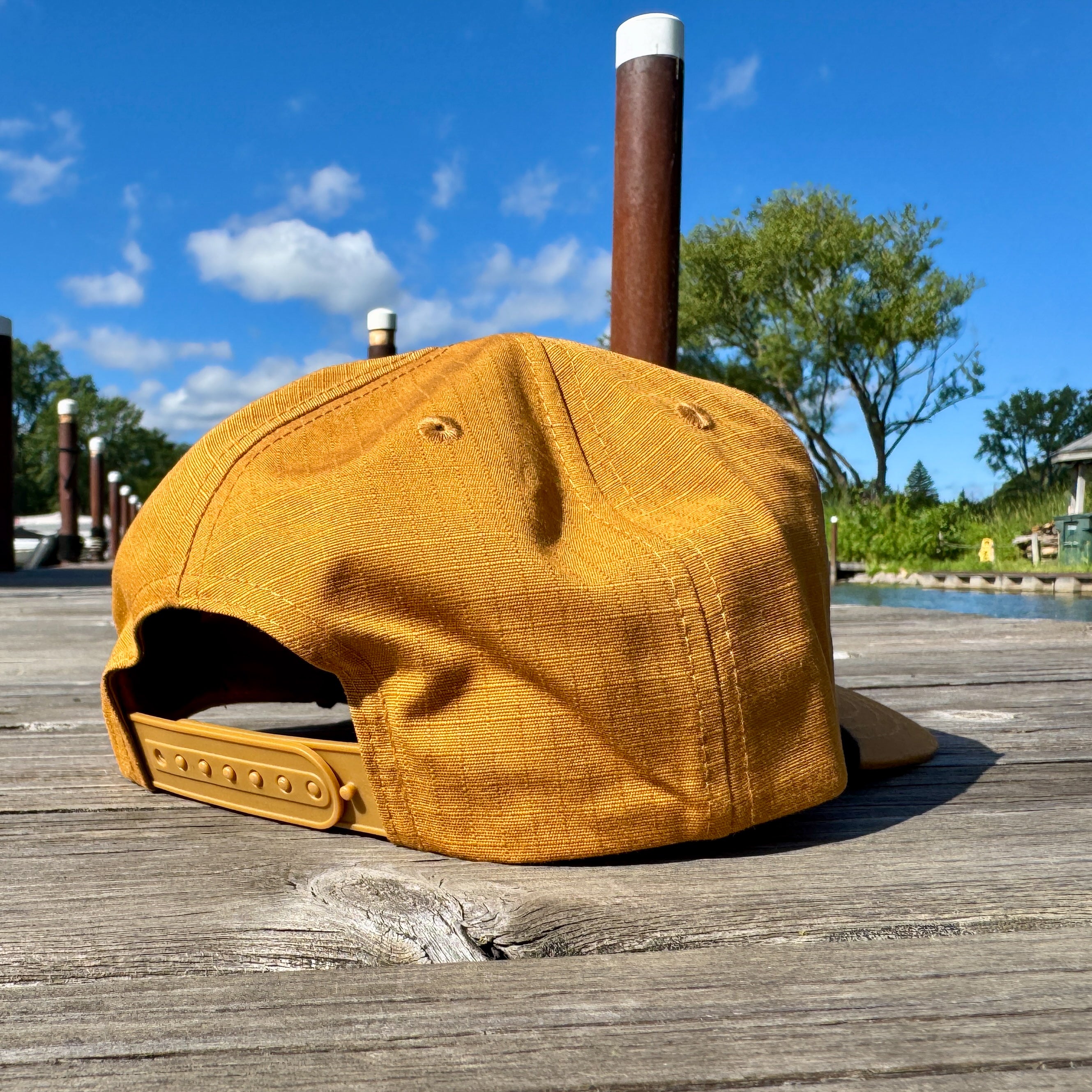 Yellow cap on a wooden surface with a scenic background