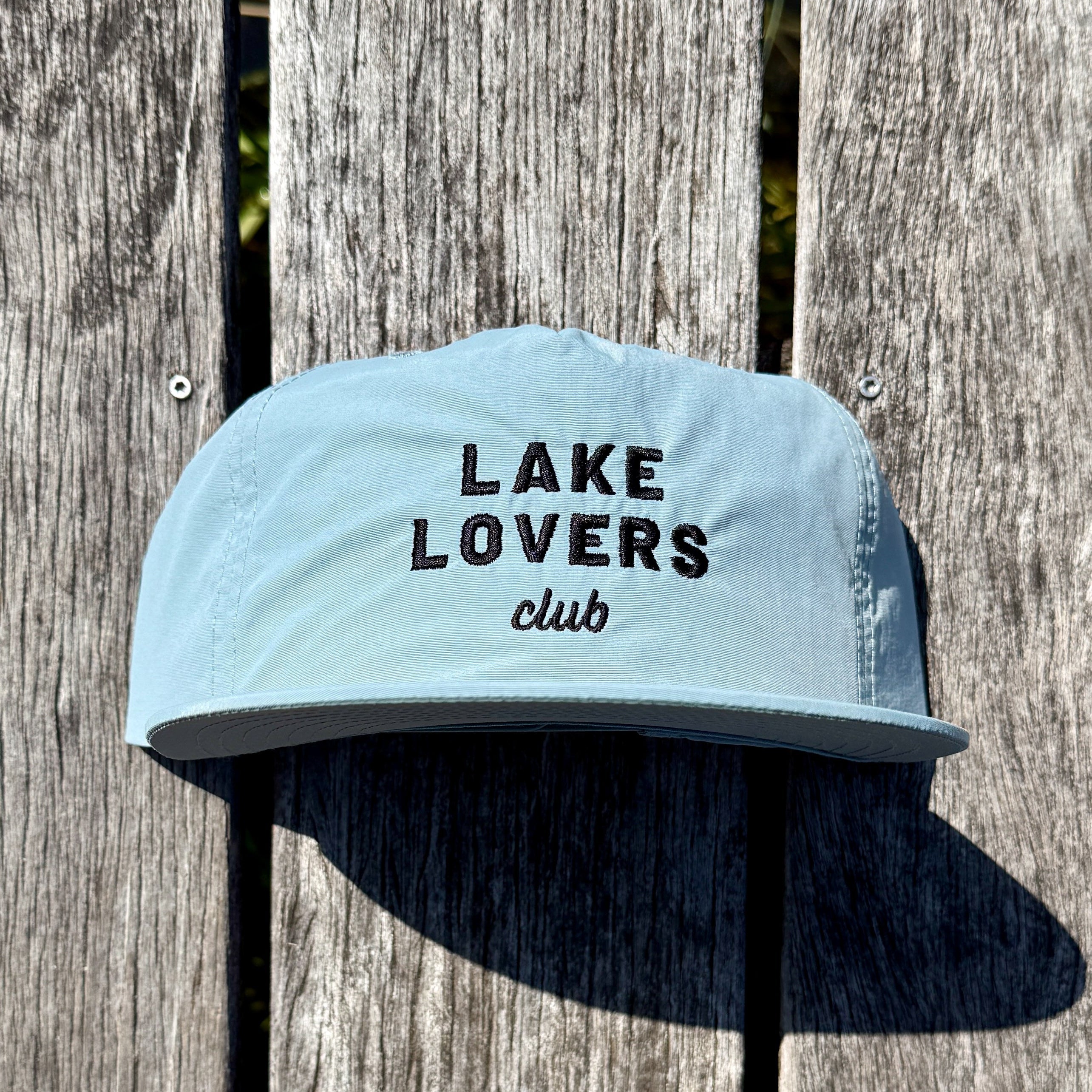Light grey cap with 'Lake Lovers club' text on a wooden background