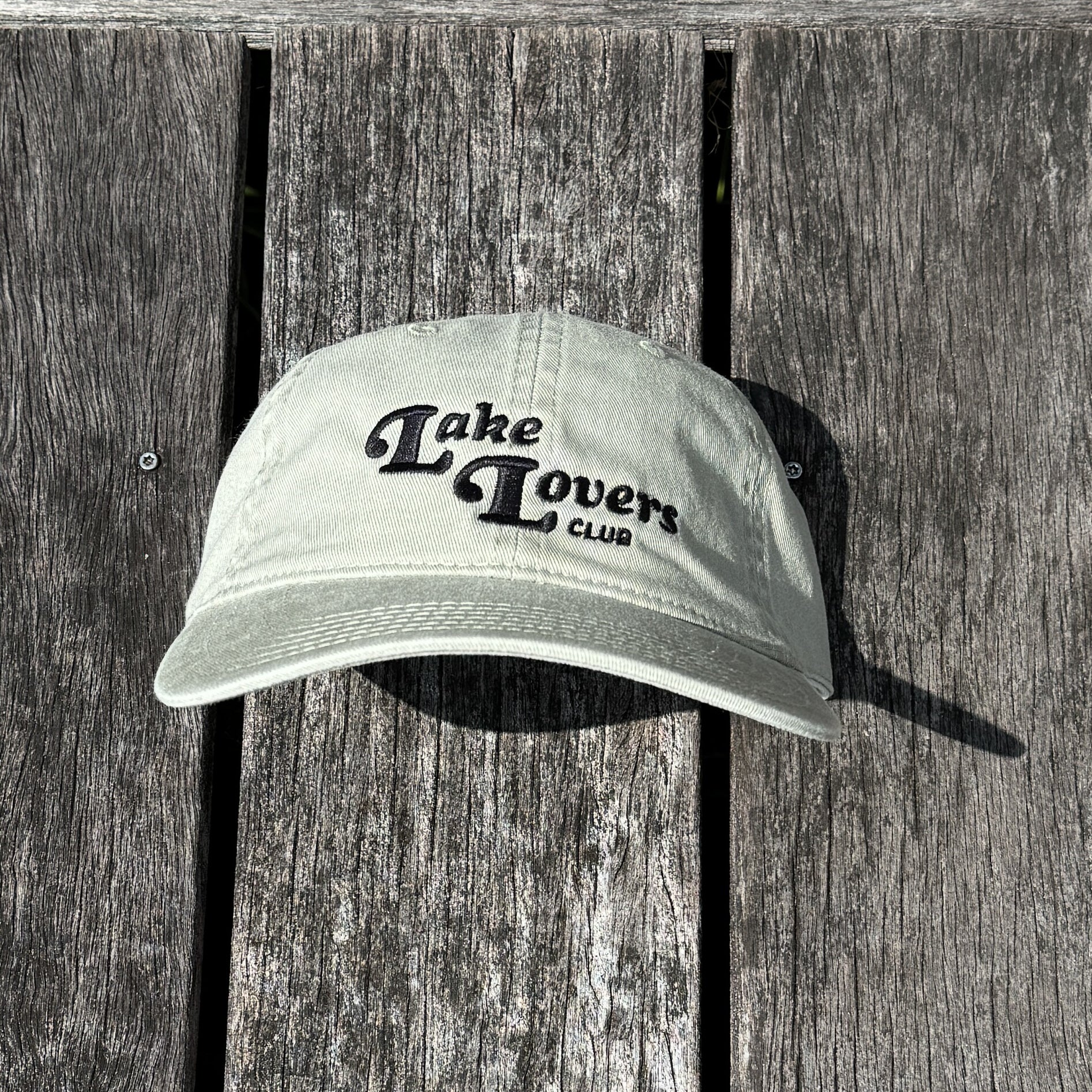 Cap with 'Lake Lovers Club' text on a wooden surface