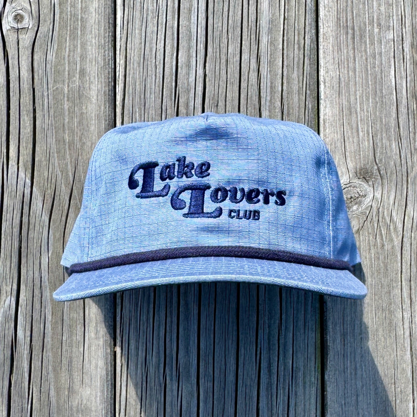 Blue cap with 'Lake Lovers Club' text on a wooden background