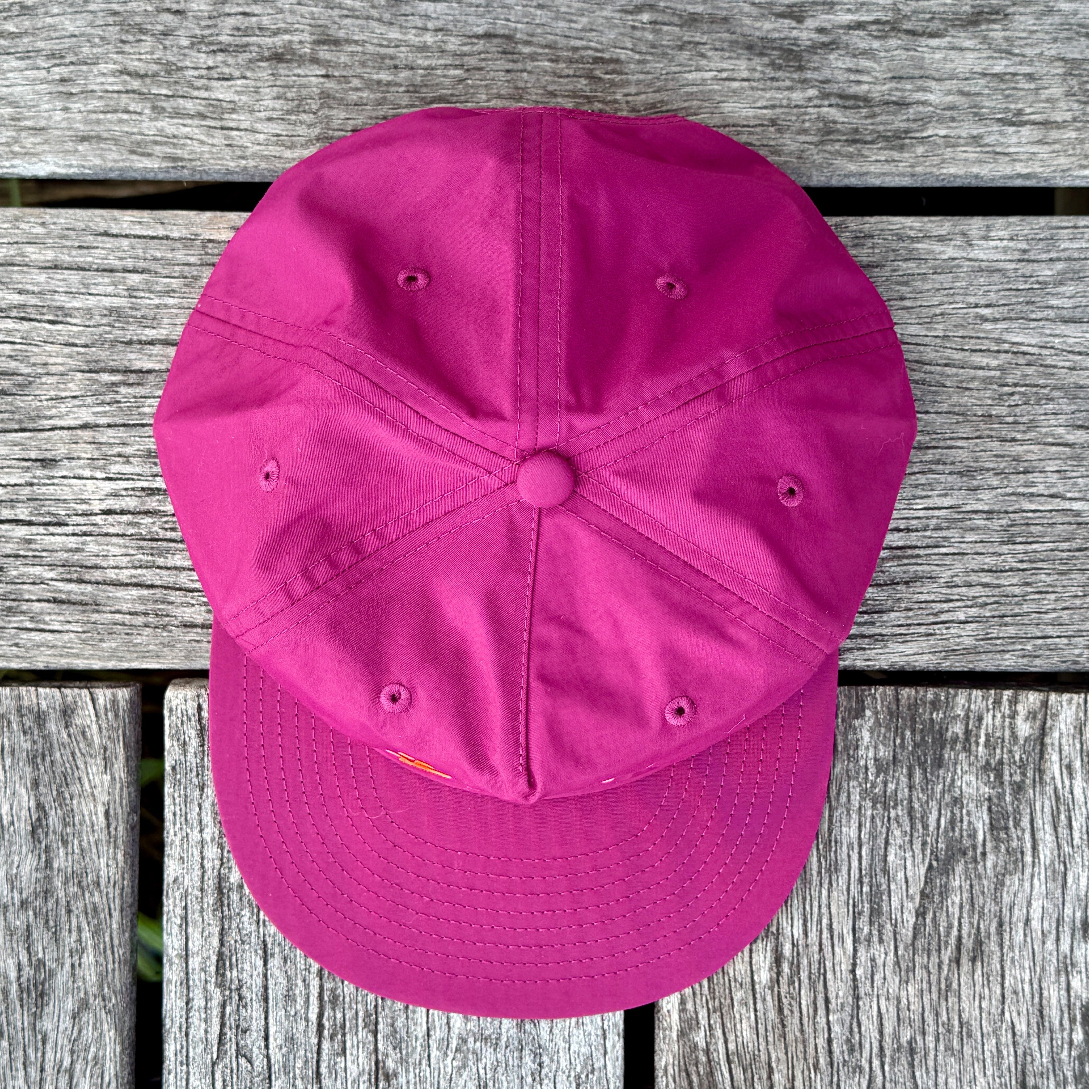 Maroon cap on a wooden surface